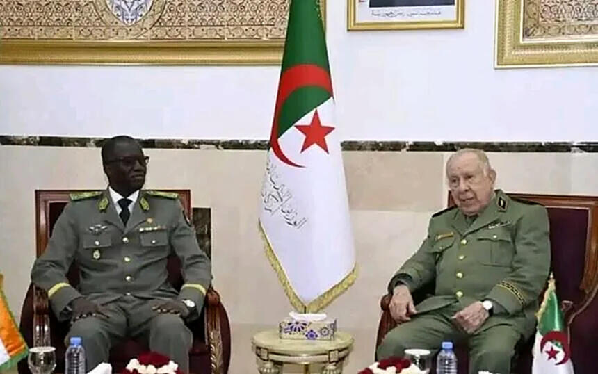 Le général d’armée Saïd Chanegriha et le ministre nigérien de la Défense nationale assis côte à côte dans des fauteuils, de part et d’autre d’un drapeau algérien.