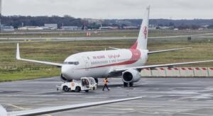 Avion d'Air Algérie remorqué sur le tarmac d'un aéroport, par temps pluvieux