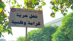 Pancarte de l’UGTT « Travail, liberté, dignité nationale » brandie lors d’une mobilisation à Tunis