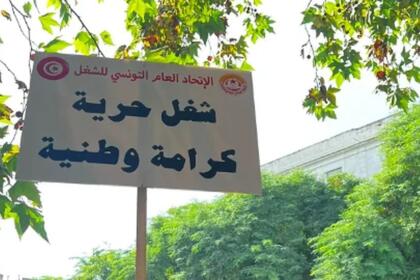 Pancarte de l’UGTT « Travail, liberté, dignité nationale » brandie lors d’une mobilisation à Tunis